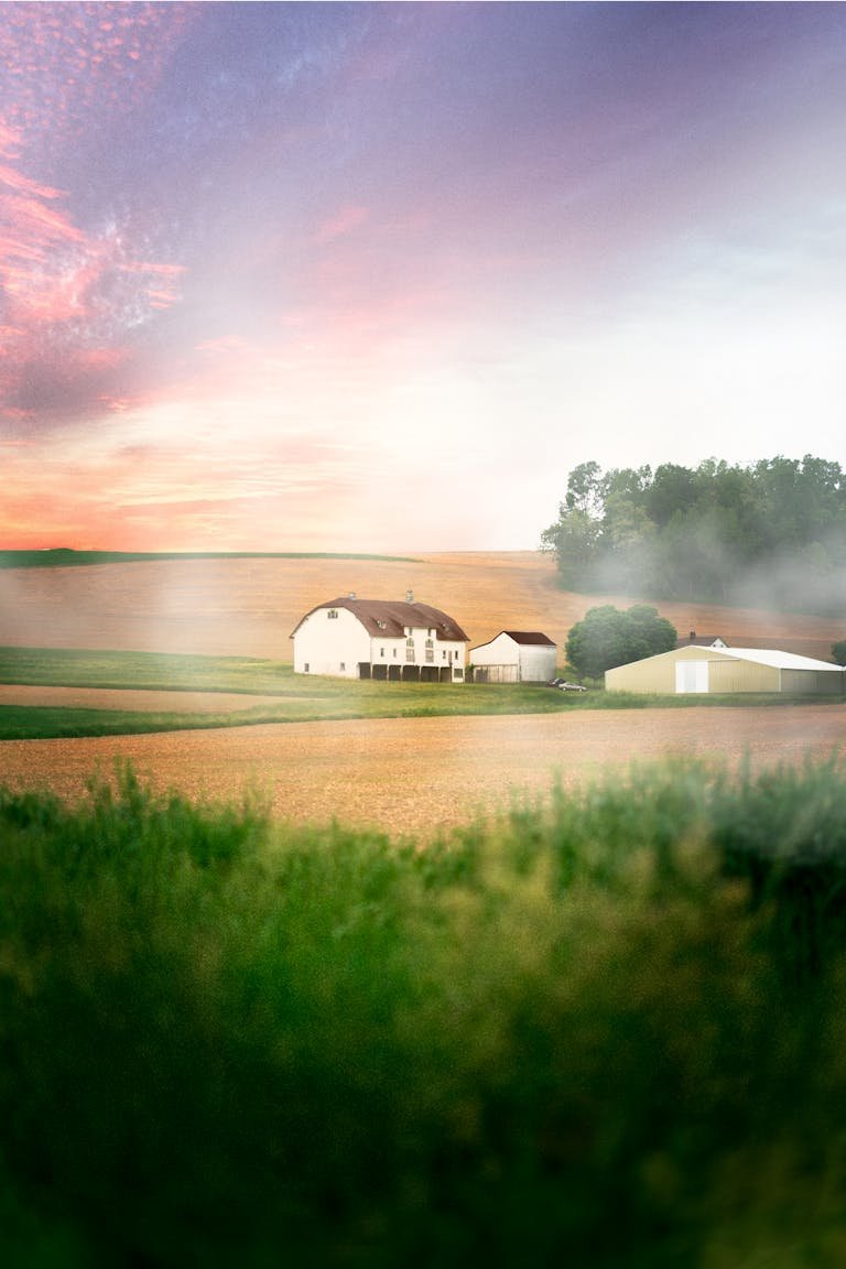 A picturesque farmhouse amidst misty fields during sunrise in Kutztown, Pennsylvania.