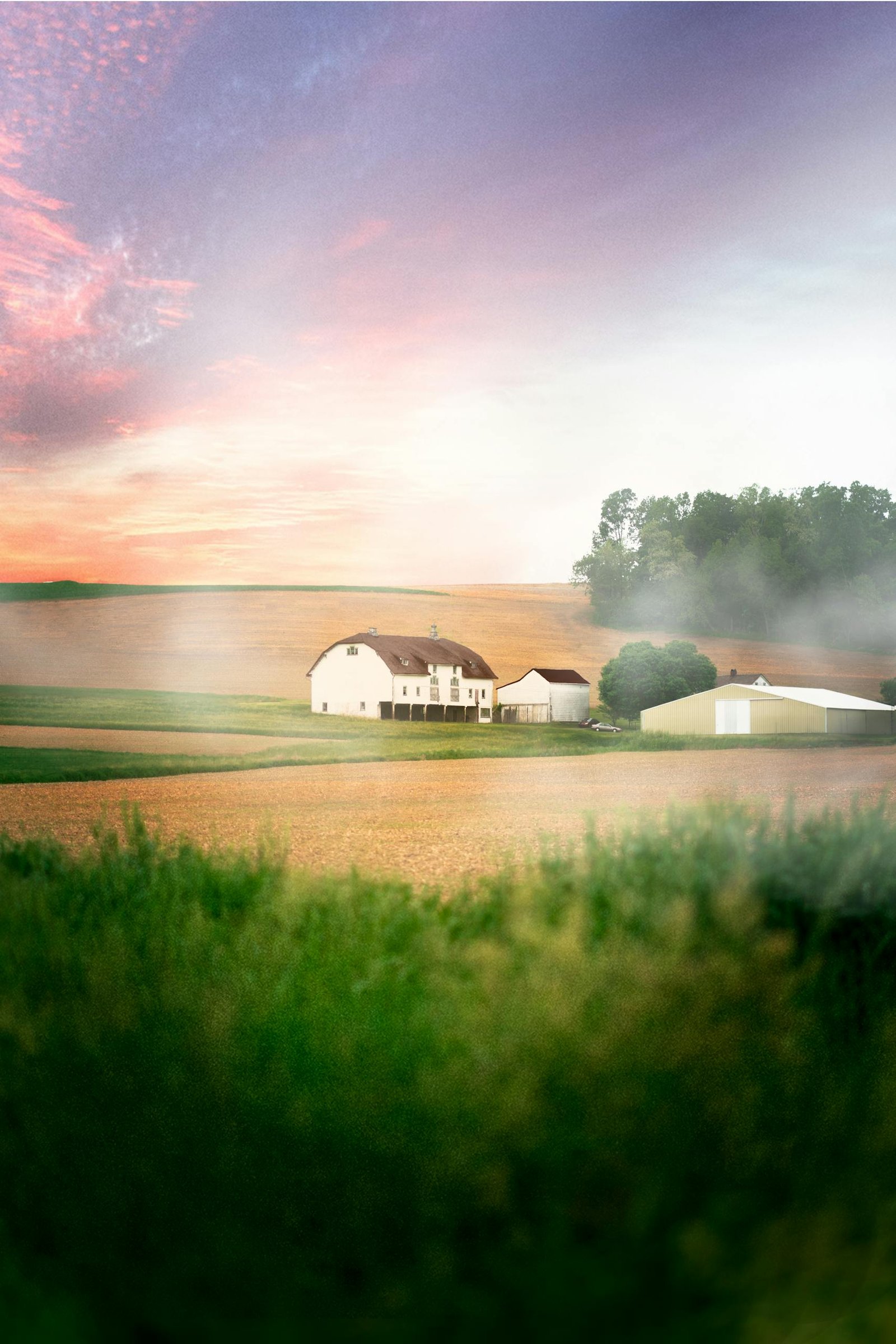 A picturesque farmhouse amidst misty fields during sunrise in Kutztown, Pennsylvania.