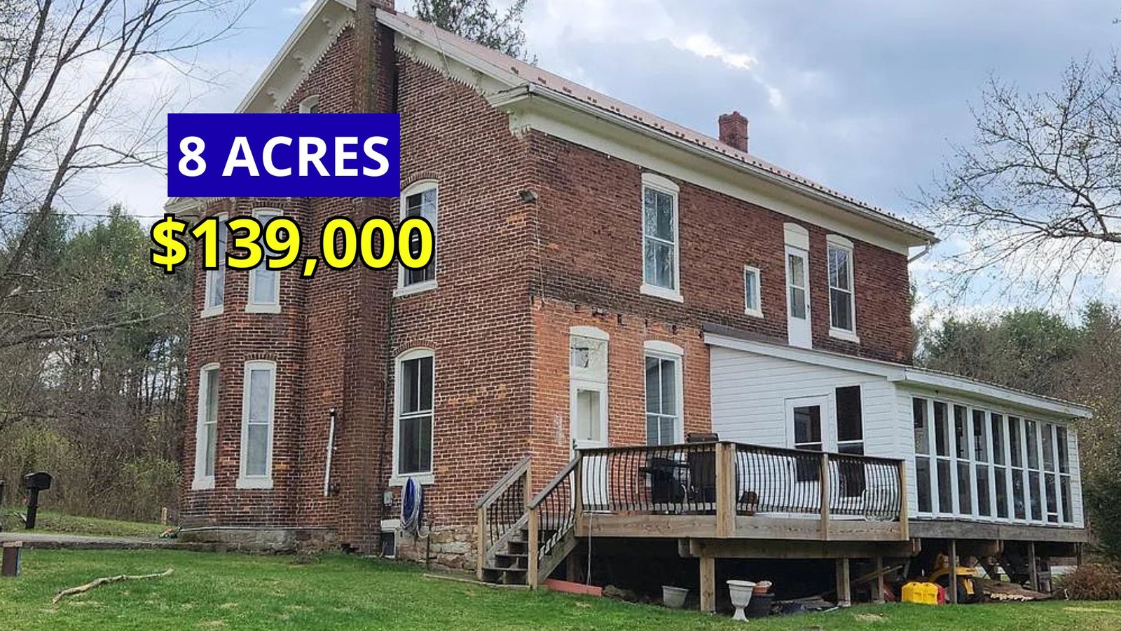 Exterior view of a stately brick farmhouse with turrets on 8 acres for sale at $139,900 in Huntingdon, Pennsylvania