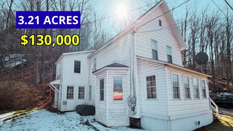 Exterior view of a two-story home on 3.21 acres with public water and sewer for sale at $130,000 in Dushore, Pennsylvania