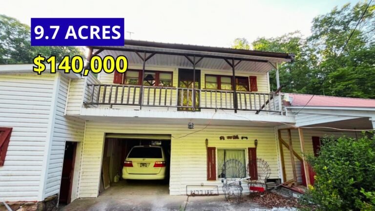 Exterior view of a main house with two additional mobile homes on 9.7 wooded acres with a creek and pond for sale at $140,000 in Waynesboro, Tennessee