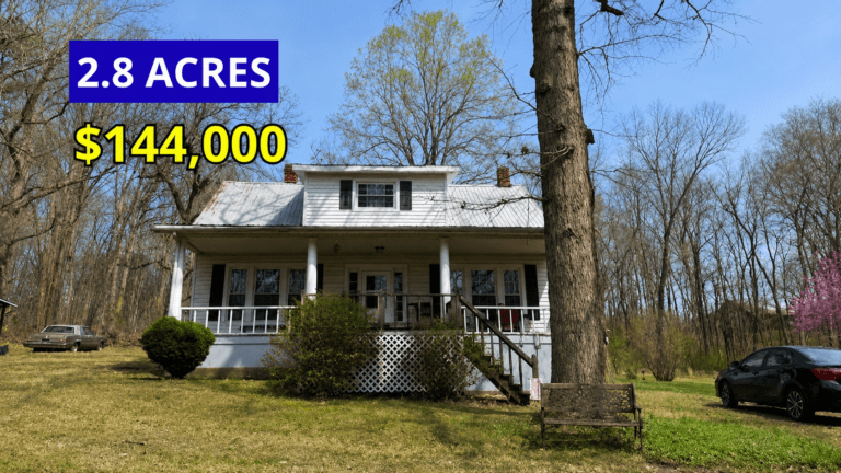 Exterior view of a 1920 farmhouse with rocking chair porch on 2.8 acres for sale at $144,000 in Long Island, Virginia