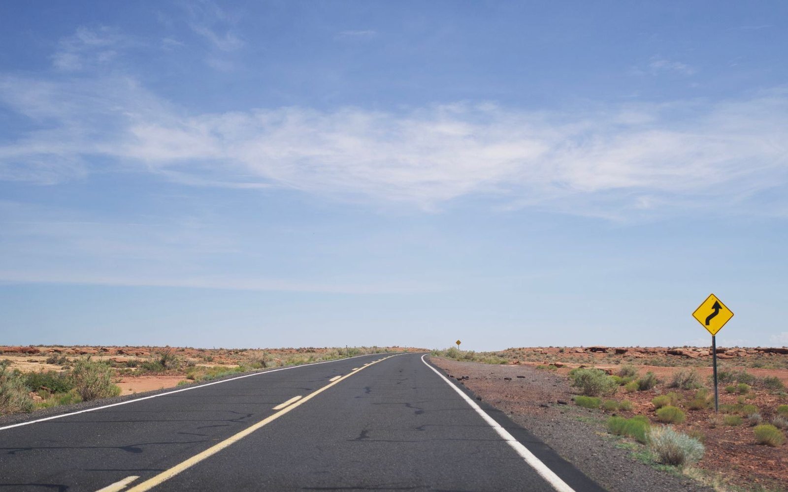 Two-lane highway running through red rock desert country in rural Arizona