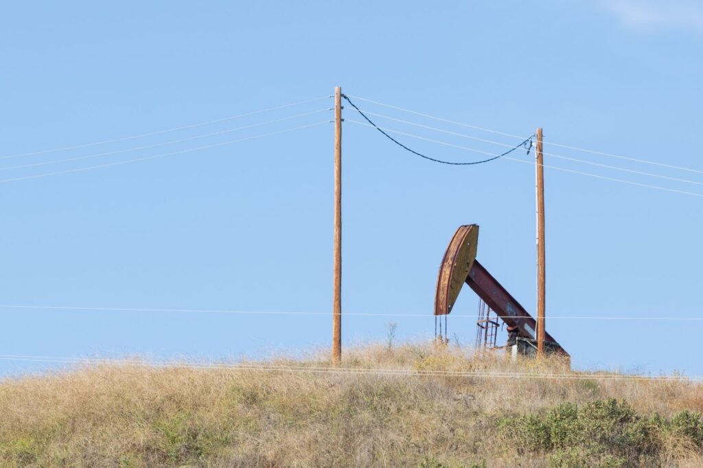 Oil pumpjack on rural grazing land under power lines