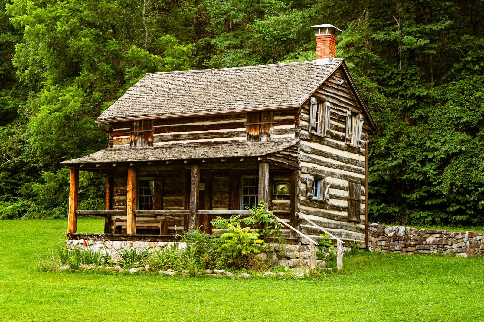 Historic stacked-log cabin with chinked walls, a front porch and a brick chimney in Fort Valley, Virginia