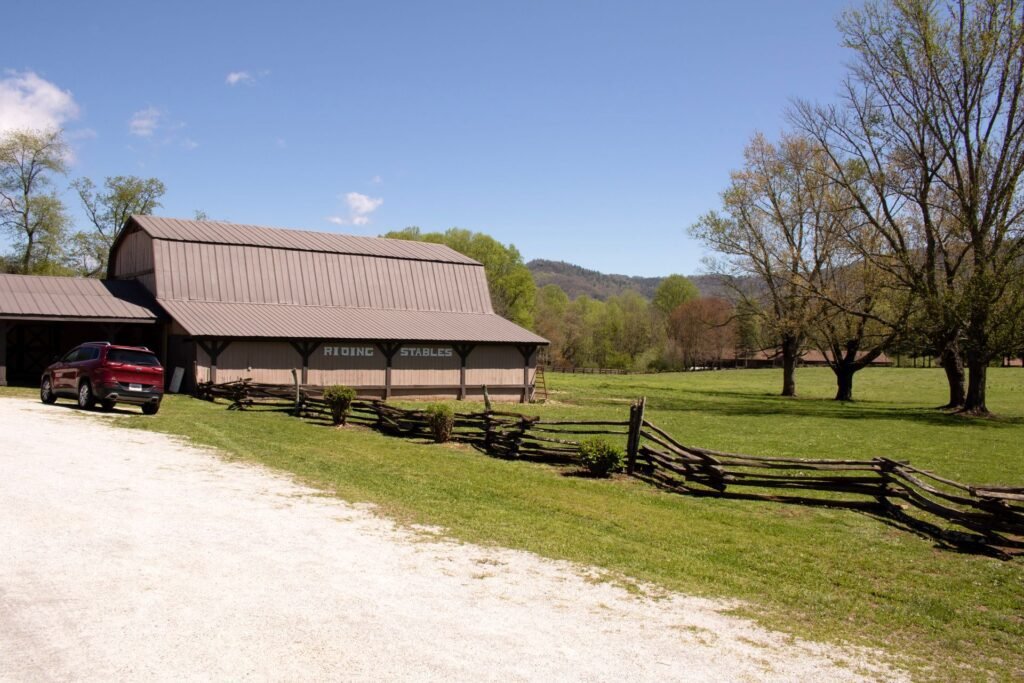 Rural land to buy in Georgia: wooden stables, split-rail fence and gravel drive in Dillard, Rabun County